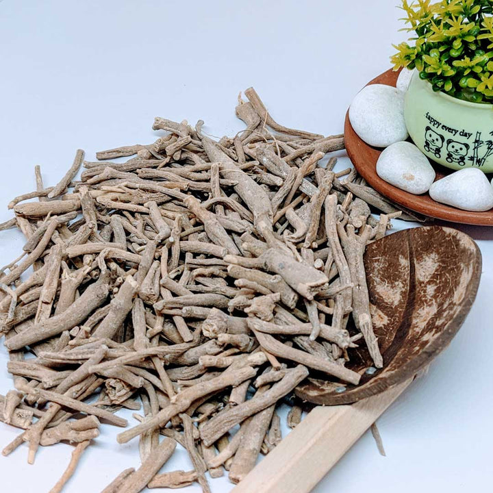 Pile of dried ashwagandha roots with rough texture and beige color, emphasizing their natural appearance.