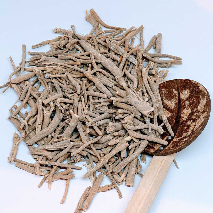 Pile of dried ashwagandha roots with rough texture and beige color, emphasizing their natural appearance.