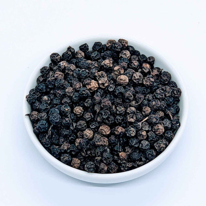 A pepper grinder filled with fragrant black peppercorns, ready to be freshly ground,Piper Nigrum