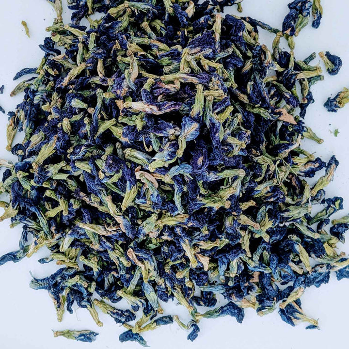 Dried butterfly pea flowers spread on a table, ready for brewing butterfly pea flower tea.