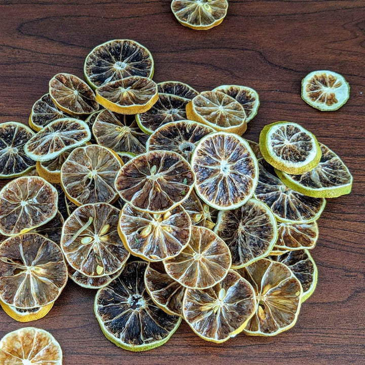 Dried lemon slices on a wooden surface,Dried Lime Chips: Zesty, Crunchy & Naturally Sweet.